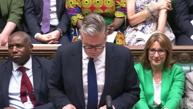 Keir Starmer speaks, with Rachel Reeves behind him in a green blazer looking emotional