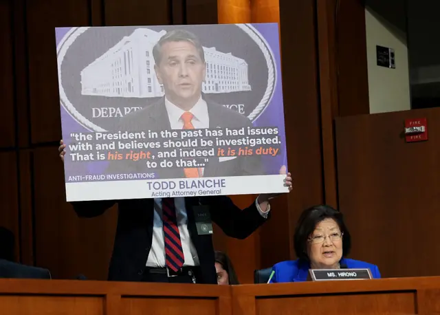 Hirono in the lower right corner and in front of a poster featuring a photo of Blanch and the quote "the President in the past has had issues with and believes he should be investigated. That is his right and indeed it is his duty to do that"