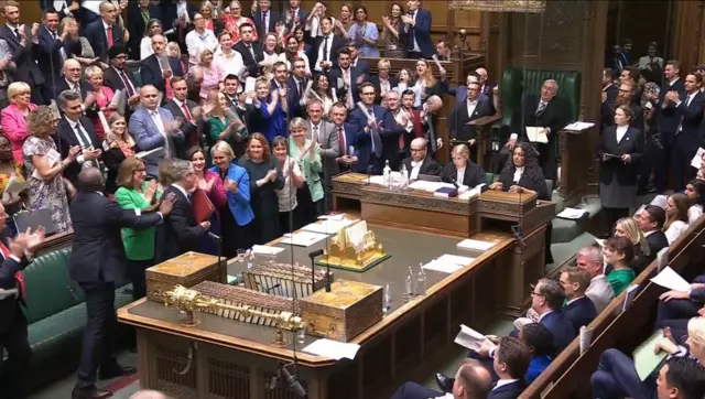 Labour MPs stand to Keir Starmer as he makes his way across the chamber, while Conservative MPs remain seated