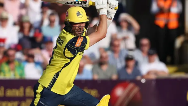 Hampshire batter Joe Weatherley in yellow kit striking the ball against Essex