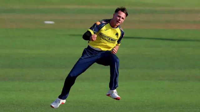 Sonny Baker jumps in the air to celebrate a wicket