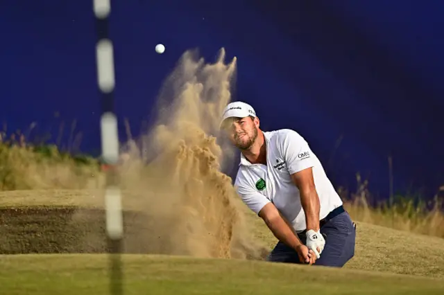 Pierceson Coody plays from a green-side bunker