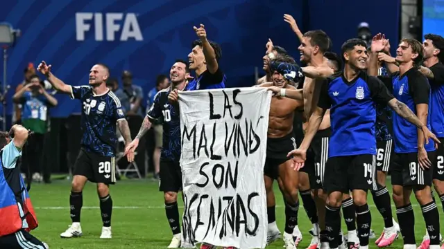 Argentina's players hold a banner reading "The Malvinas (Falkland Islands) belong to Argentina," after beating England at 2026 World Cup