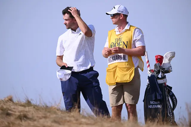 Nicolai Hojgaard of Denmark and his caddie look on