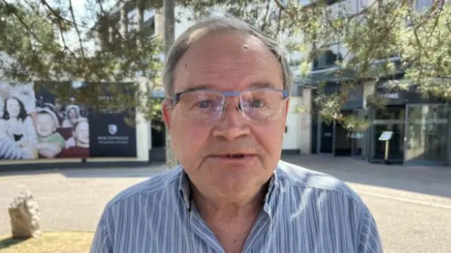 man with glasses in blue striped shirt