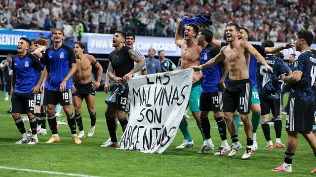 The Argentina players celebrate at full time with a banner that reads "The Falkland Islands are Argentinian" during the FIFA World Cup 2026 Semi Final match between England and Argentina at Atlanta Stadium on July 15, 2026 in Atlanta, Georgia