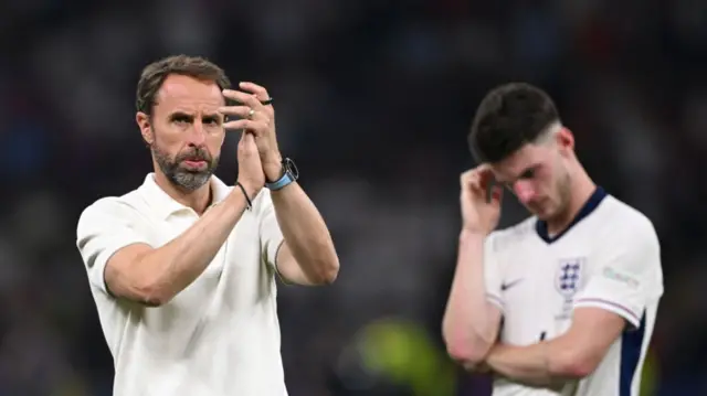 England coach Gareth Southgate applauds the fans as Declan Rice reacts dejectedly after England had lost 2-1 to Spain during the UEFA EURO 2024 final match between Spain and England at Olympiastadion on July 14, 2024 in Berlin, Germany.