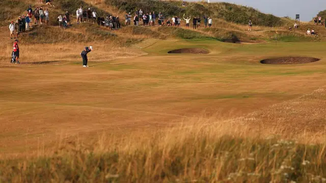 A wide shot of Ryan Fox playing on a baked and brown course