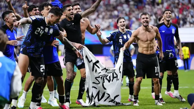 : Giovani Lo Celso and Cristian Romero of Argentina celebrates the victory and hold up a banner after winning the 2026 FIFA World Cup semifinal match between England and Argentina at Atlanta Stadium in Atlanta, Georgia, United States, on July 15, 2026.