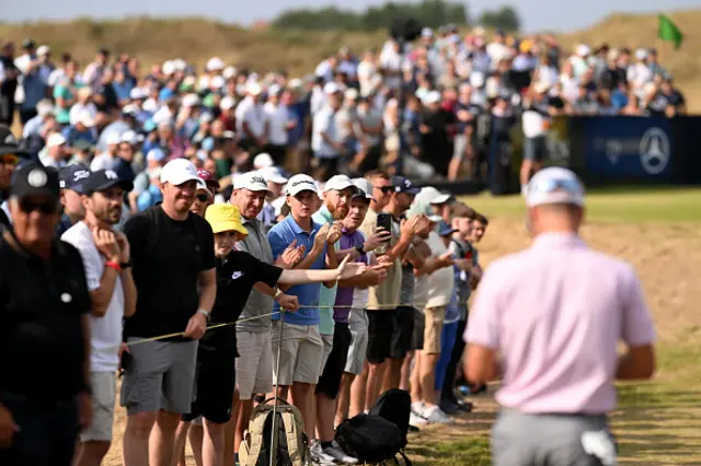 Spectators look on as Justin Thomas of the United States walks