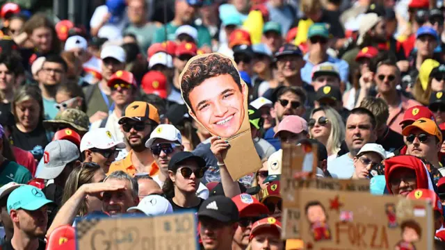 fan holding up a cut out of Lando Norris