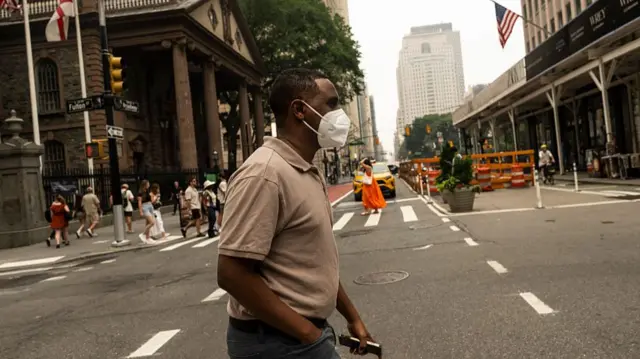 A man in an N95 mask walks across the street in Manhattan.