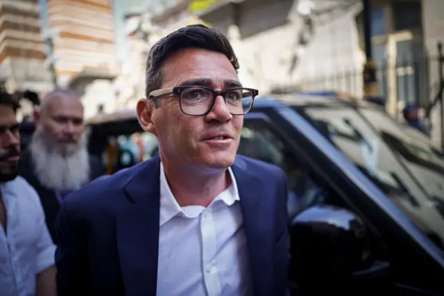 Andy Burnham pictured in front of a black cab in Westminster