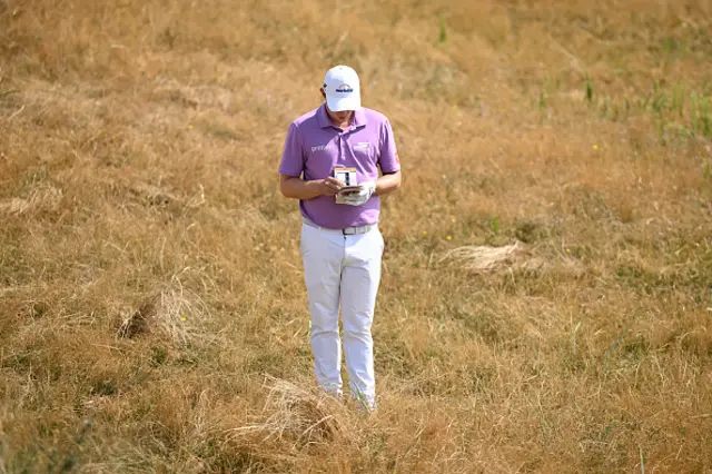 Matt Fitzpatrick of England checks his yardage