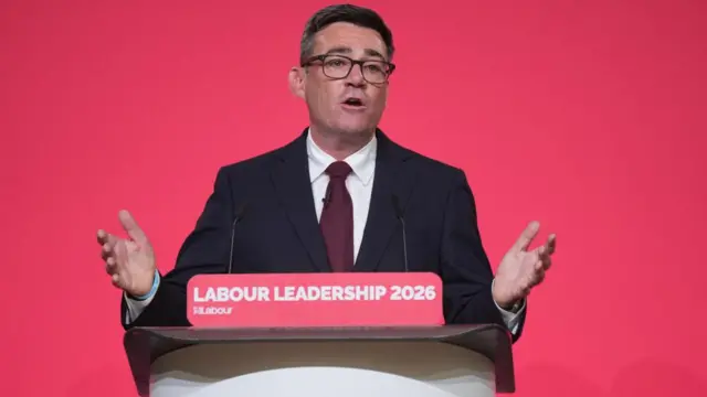Andy Burnham speaking into a lectern