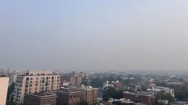Photo shows skyline from rooftop in Washington DC on a hazy day, with smoke polluting the air following Canadian and US wildfires