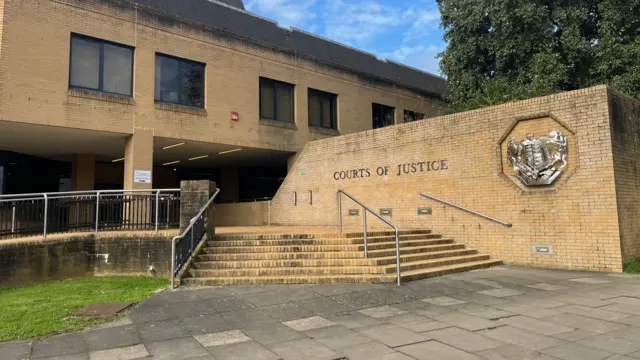 Outside Southampton Crown Court, where there is a sign reading "courts of justice"