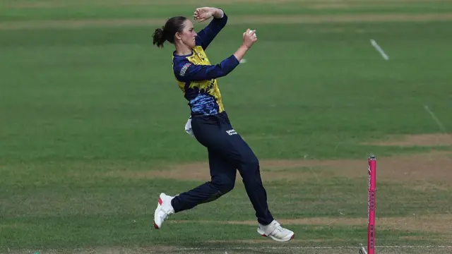 Sophia Turner runs in to bowl
