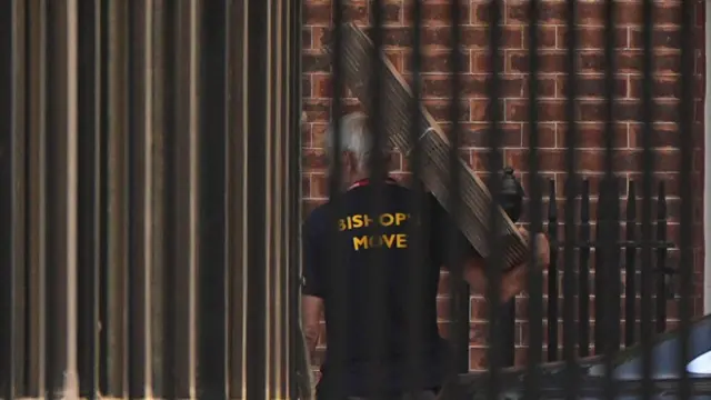 A worker from Bishop's Move carrying something into the premises of Downing Street
