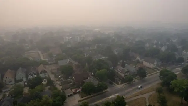 Smoke hangs over a residential area, pictured from the sky, in Milwaukee