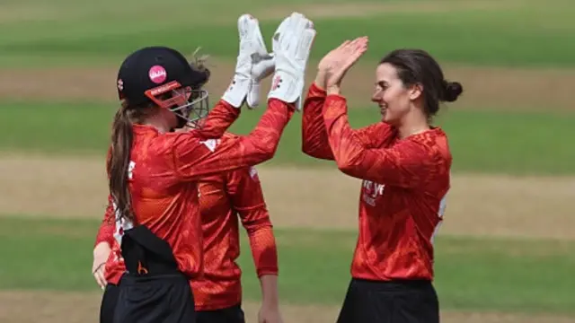 The Blaze players, wearing red, celebrate a wicket