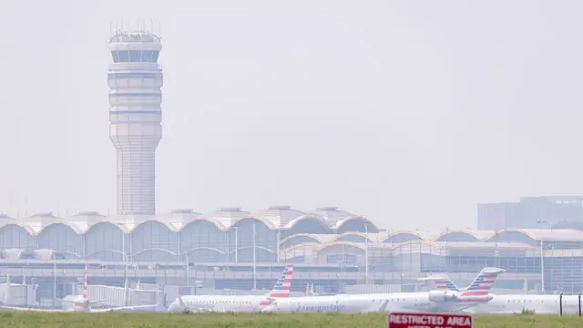 Smoke from massive wildfires in Canada and Minnesota engulf the Washington, D.C. skyline, reducing visibility and casting a colored haze over the Ronald Reagan Washington National Airport