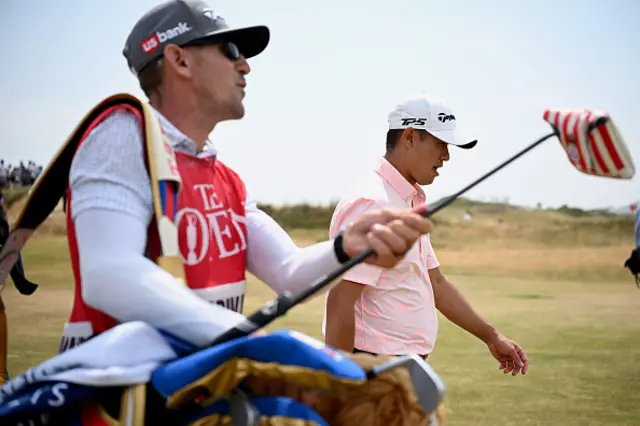 Collin Morikawa of the United States and his caddie walk on