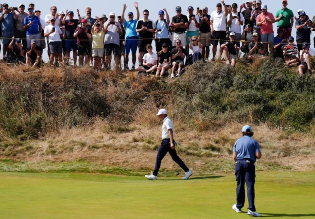 Spectators celebrate after Tommy Fleetwood of England putts a birdie