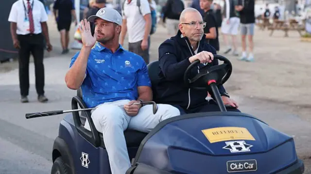 Bryson DeChambeau waves to spectators