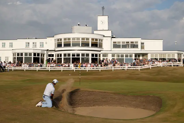 Jon Rahm chips out of the bunker