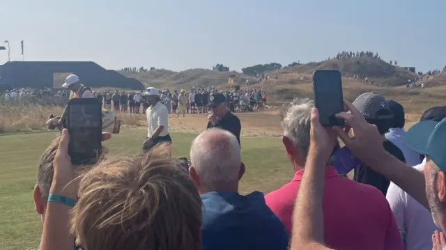 Fans watch Tommy Fleetwood walking to the 10th tee
