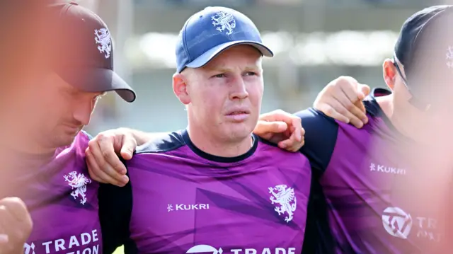 Somerset's James Rew, wearing a purple Somerset training top, pictured in a huddle before Finals Day