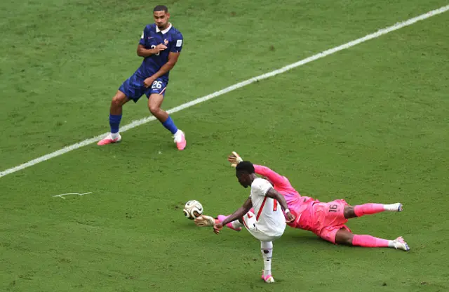 Bukayo Saka #7 of England scores his team's third goal against Mike Maignan #16 and Maxence Lacroix