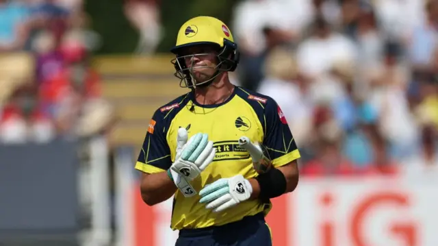 Tristan Stubbs with his bat under his left arm after being dismissed