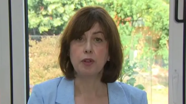 Lucy Powell wears a blue jacket and sits in front of a garden door as she is interviewed by Laura Kuennsberg