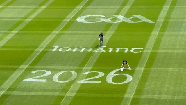 Last minute touch up to the logos on the pitch