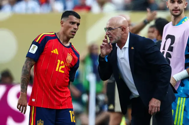Spain's head coach Luis de la Fuente speaks to defender #12 Pedro Porro