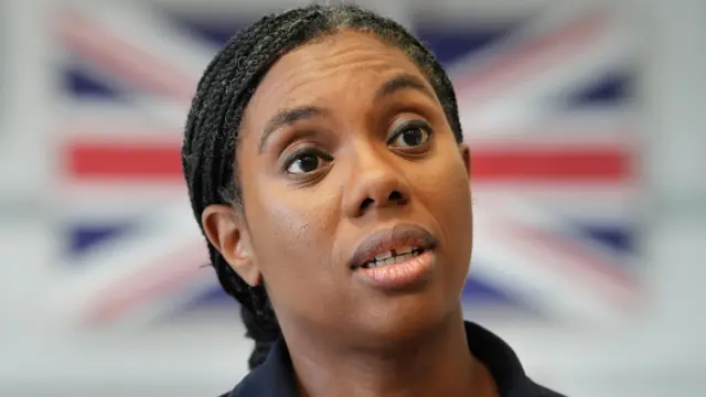 Conservative Party leader Kemi Badenoch standing in front of a Union Jack flag