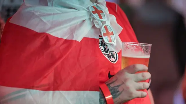 England fan holds a beverage in a pub