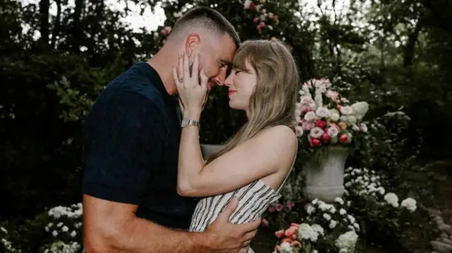 Travis Kelce and Taylor Swift embrace in their engagement photo
