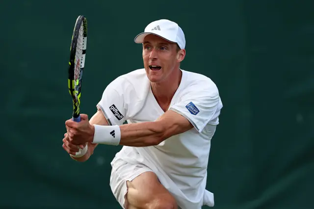 Jan Choinski holds a tennis racquet