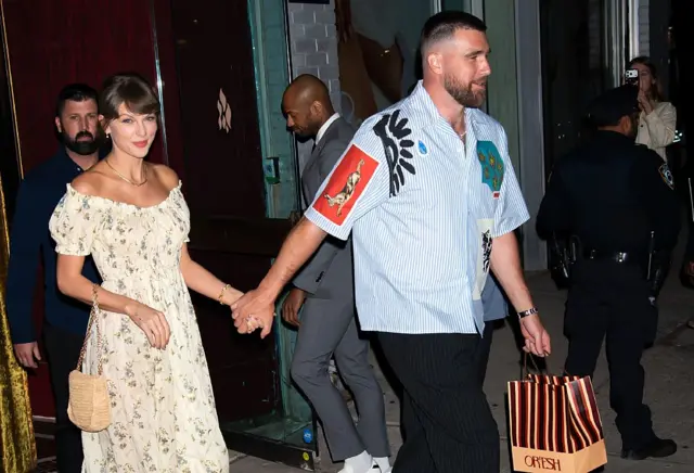 Taylor Swift and Travis Kelce leave a restaurant together with a take-out bag