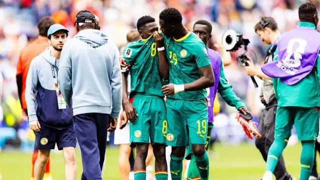 Moussa Niakhaté of Senegal comforts teammate Lamine Camara