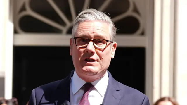 Κοντινό πλάνο του Keir Starmer με κοστούμι να στέκεται έξω από το Νο 10 και να εκφωνεί μια ομιλία