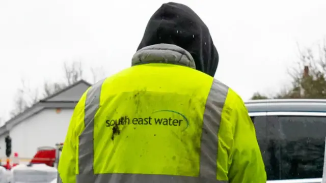 A person in a high vis yellow jacket with "South East Water" on the back.