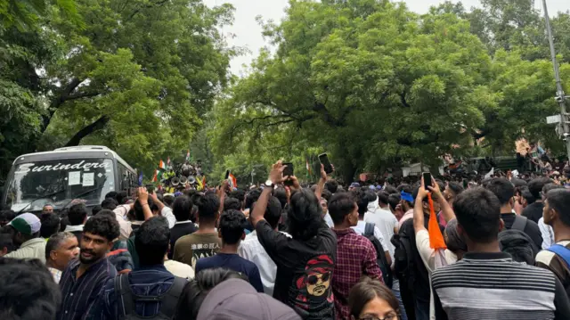 Protesters standing with phones in their hand in Delhi