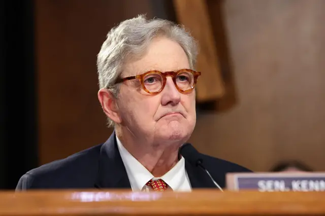 Close up of glasses-wearing Kennedy frowning