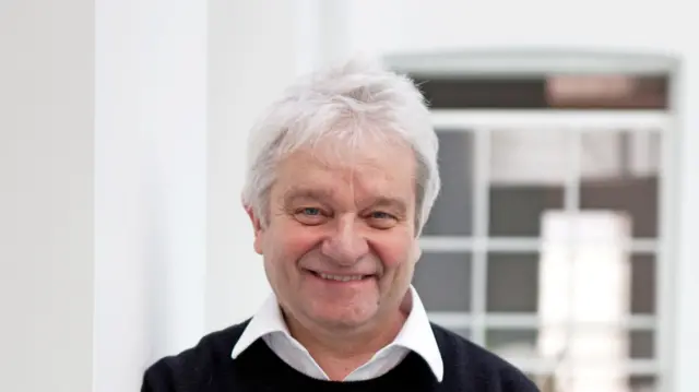 Sir Paul Nurse, a man wearing a white shirt and dark sweater.