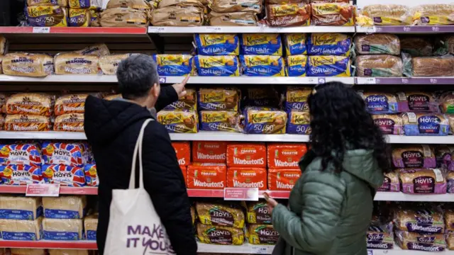 People looking at bread in a supermarket