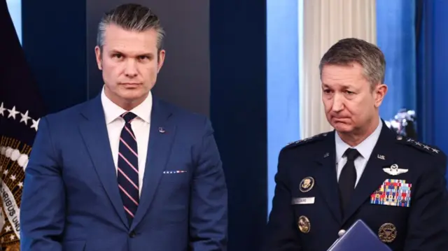 Pete Hegseth and Dan Caine listen during a media briefing from the White House in Washington